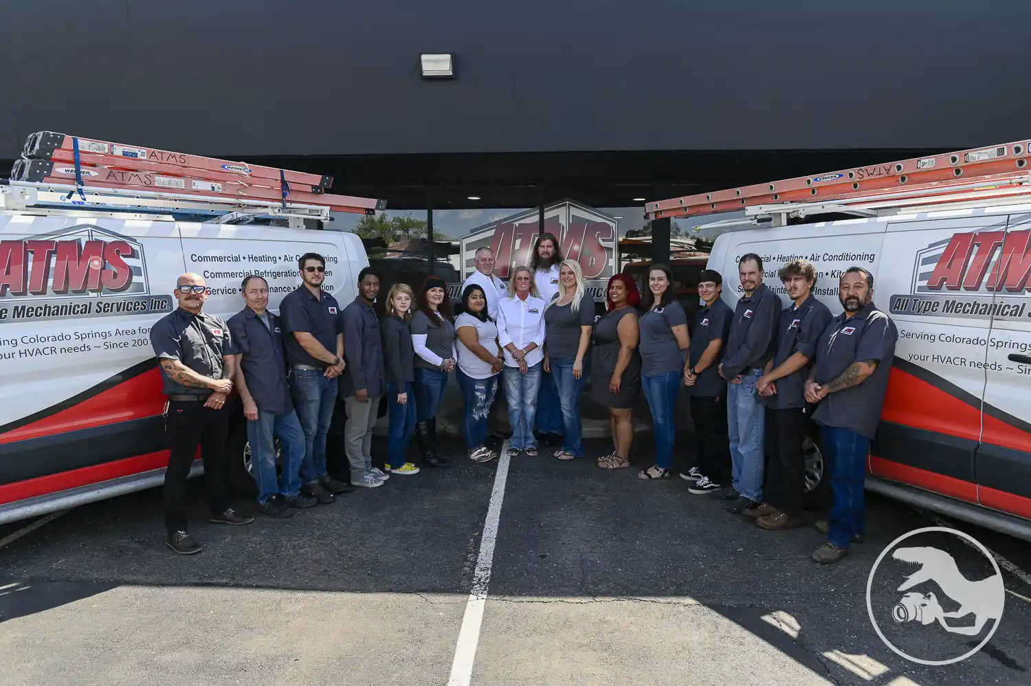ATMS team picture in front of building with ATMS Vans